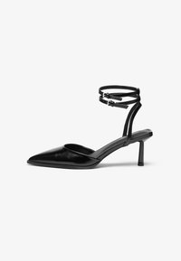Chaussure à talon haut en cuir noir avec un bout pointu et une bride de cheville. Présente un design épuré et un talon fin de 5 cm. Texture lisse.