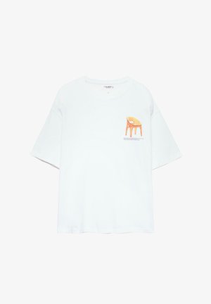 T-shirt blanc à manches courtes avec une coupe décontractée, présentant une illustration d'une chaise orange et un texte sur la zone gauche de la poitrine.