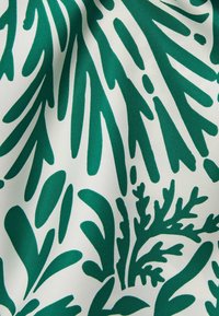 Des motifs de feuilles vertes sur un fond en tissu blanc. Le matériau est lisse et présente diverses formes et tailles de feuillage.