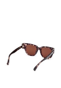 Tortoiseshell sunglasses with round frames, brown lenses, and thin arms. Features metal detailing on hinges and sleek, glossy finish.