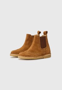 Brune semskede ankelstøvler med elastiske sidepaneler, brogue-detaljer omkring tåen og løftestropper for nem påsætning. Flad gummisål.
