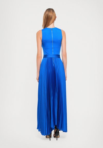 Blaues, plissiertes Maxikleid mit einem taillierten Oberteil und einem Reißverschlussdetail am Rücken. Glatter Stoff mit einem fließenden Design. Sichtbare Absätze.