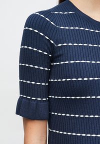 Μπλούζα από ριμπ πλεκτό ύφασμα σε ναυτικό στυλ με λευκές οριζόντιες ρίγες, με κοντά μανίκια και γυρισμένα τελειώματα. Μαλακή υφή και εφαρμοστό σχέδιο.