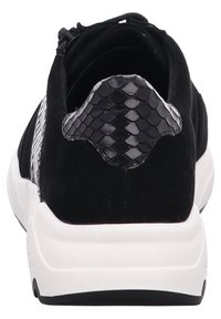 Black sneaker with a textured snake-patterned heel, suede upper, and contrasting white sole. Features a rounded shape and lace closure.