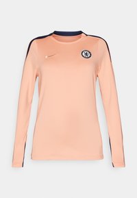 Långärmad tröja i ljus persika med marinblå detaljer, med rund halsringning, Nike-logotyp och Chelsea FC-märke på bröstet.