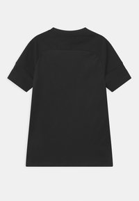 Camiseta negra de manga corta con una textura suave y escote redondo. Presenta un diseño liso en la parte trasera sin logotipos ni patrones visibles.