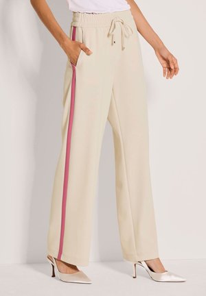 Beige Hosen mit weitem Bein, elastischem Bund, pinken Seitenstreifen und Seitentaschen; glatter Stoff, kombiniert mit spitzen Absätzen.