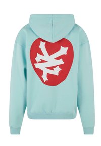 Turkis hoodie med et stort rødt hjertegrafikk med hvite beinformede former. Laget av mykt materiale med ribbede mansjetter og hem.