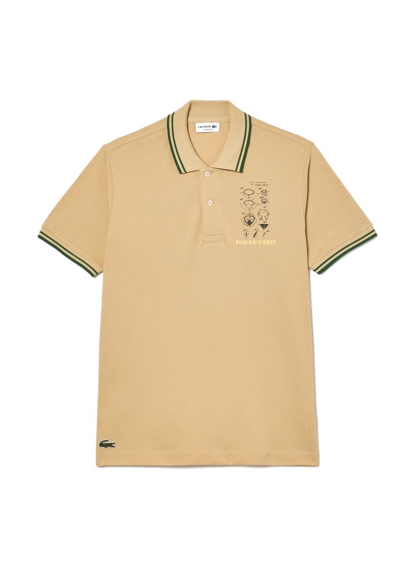 Camisa polo beige con cuello y mangas a rayas verdes, que presenta un estampado gráfico en la parte frontal, hecha de tejido de algodón texturizado.