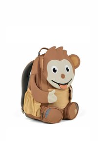 Affe-förmiger Rucksack aus braunem und beigem Stoff, mit einem lächelnden Gesicht, großen Augen und strukturierten Akzenten. Reißverschlussfach an der Unterseite.