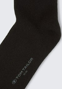 Sosetă neagră din bumbac, cu o textură moale, având un design rib pentru un plus de stil și un logo imprimat "TOM TAILOR" cu detalii despre mărime aproape de gleznă.