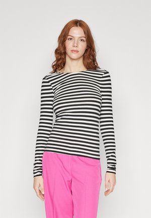 Black and white striped long-sleeve shirt with a boat neck design. Smooth fabric, featuring fitted sleeves and a classic cut. Paired with pink trousers.