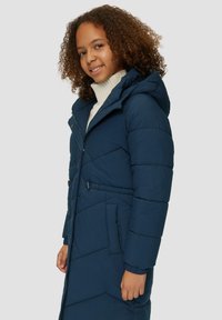 Marineblauer Puffer-Mantel mit Kapuze, der eine taillierte Silhouette, einen Reißverschluss und ein diagonales Steppmuster aufweist. Hergestellt aus weichem, isolierendem Material.