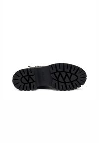 Suela de bota de goma negra con tacos profundos, que presenta un diseño texturizado y el nombre de la marca "FRAU" grabado en el lateral.