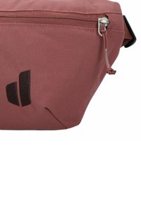 Rote Stofftasche mit glatter Textur, ausgestattet mit einem Reißverschluss, einem kleinen Kordelzug und einem schwarzen Logoakzent an der Seite.