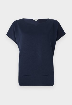 Top bleu marine à manches courtes, avec une coupe décontractée, un col rond et une texture subtile. Tissu doux avec un ourlet qui s'incurve légèrement vers le haut.