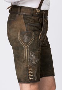Bruna lädershorts med dekorativ sömnad, prydda med broderade mönster, sidfickor och mässingsknappar på sidan.