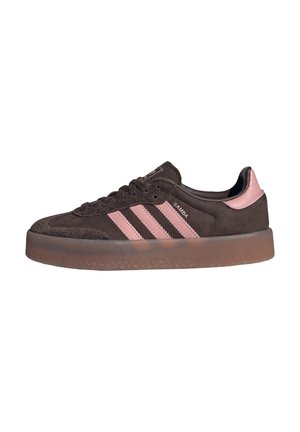 Brązowy zamszowy sneaker Adidas Samba z różowymi pasami, różową zakładką na piętę oraz przezroczystą gumową podeszwą, widok z boku na białym tle.