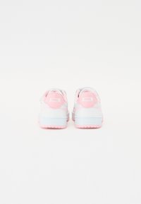 White sneakers with pink accents, featuring a smooth leather texture, round toe, padded collar, and rubber sole. Logo on heel.