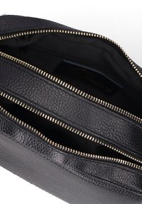 Borsa in pelle nera con superficie testurizzata. Presenta zip di colore dorato e diversi scomparti interni, foderati in tessuto nero.