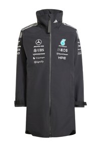 Sort lang racerkøjerjakke med fuld lynlås foran, høj krave og hvide sponsormærker inklusive Mercedes, Petronas og INEOS.