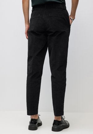Pantalons noirs fuselés avec une finition en tissu lisse, comportant un détail de poche arrière et une taille élastique pour plus de confort.