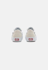 Sneakers med en ljusgrå och vit ovandel, mockadetaljer och gummisula. Har logotypdetalj på hälen och en låg design.