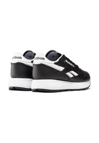 Czarno-białe sneakersy Reebok wykonane z materiałów skórzanych i siateczkowych. Posiadają białą śródpodeszwę, akcenty z logo oraz teksturowane gumowe podeszwy.