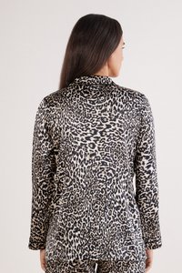 Chemise à manches longues ornée d'un motif léopard noir et beige, avec une texture douce et lisse et un col.