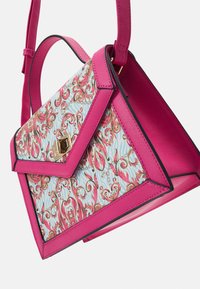 Sac à main en cuir rose avec un motif tourbillonnant floral bleu et rose, fermoir doré et bandoulière réglable, présenté en angle avec le dessus ouvert.