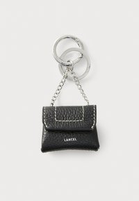 Black leather keychain purse with a flap, featuring white stitching and a silver chain attachment. "LANCEL" logo on the front.