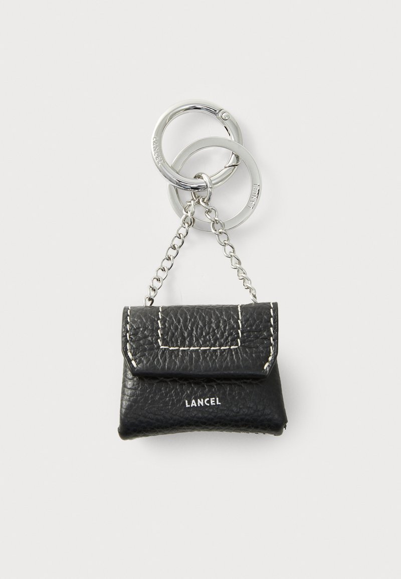 Black leather keychain purse with a flap, featuring white stitching and a silver chain attachment. "LANCEL" logo on the front.