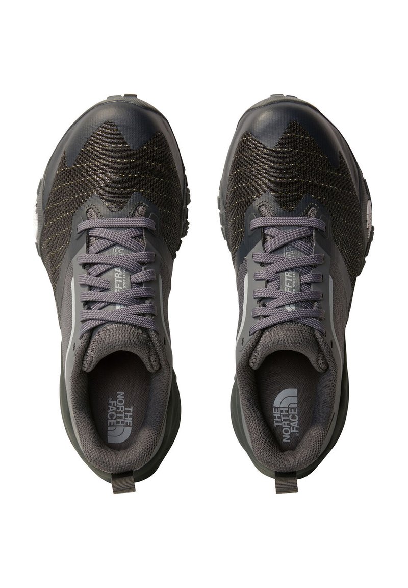 Szare buty sportowe z teksturowaną cholewką, z czarnymi i złotymi detalami, okrągłym czubkiem i amortyzowaną podeszwą; logo na pięcie i języku.