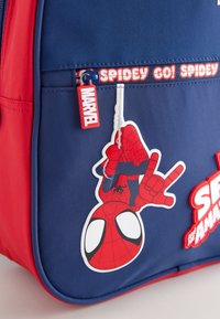 Red and blue backpack features a Spiderman graphic, zipper pull with "MARVEL" tag, and "SPIDEY GO! SPIDEY" text along the zipper.