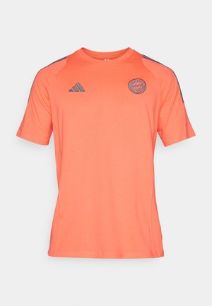 Kortermet rosa-oransje treningsskjorte laget av mykt stoff, med rund hals og mørkegrå detaljer på skuldrene og logoen.