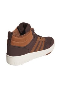 Braune High-Top-Sneaker mit strukturiertem Obermaterial, Wildlederakzenten, einem Drei-Streifen-Design und einer weißen Sohle mit Traktionsdetails.
