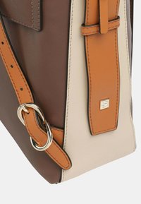 Bruine, crème en oranje lederen handtas met een gladde textuur, een slank ontwerp, zilveren hardwareaccenten en een verstelbare schouderband.