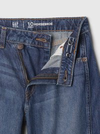 Denim jeans with a light to medium blue wash, featuring stitch detailing, a zip fly, and the brand label "GAP KIDS" on the waistband.