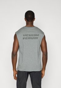 Γκρι αμάνικη μπλούζα με στρογγυλή λαιμόκοψη. Φέρει μεγάλο λογότυπο "VENUM" σε σκούρο γκρι εκτύπωση στην πλάτη. Μαλακή υφή υφάσματος.