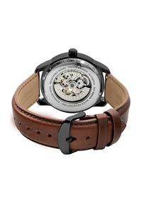 Reloj automático con fondo de caja transparente, acero inoxidable y correa de cuero marrón. Presenta un cierre negro y detalles mecánicos intrincados.