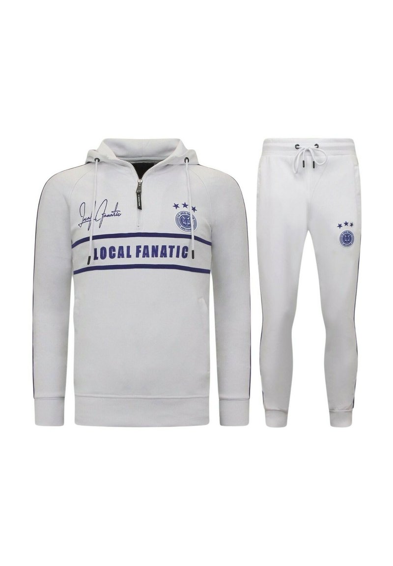 Witte hoodie met rits, zwarte accenten en een blauwe "LOCAL FANATIC" grafiek. Bijpassende witte tapered joggers met trekkoord.