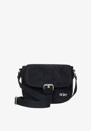 Sac bandoulière en velours côtelé noir avec sangle réglable, rabat avant sécurisé par une boucle métallique et logo "ROXY" dans le coin inférieur droit.