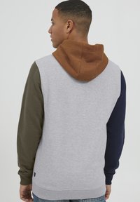 Kapuzenpullover mit grauem Körper und Ärmeln in Olivgrün, Marineblau und Braun. Weicher Stoff mit gerippten Bündchen und Saum.