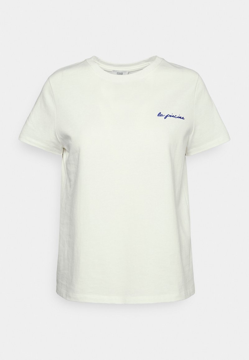 T-shirt blanc à manches courtes et col rond avec un petit texte en cursive bleue "la piscine" sur le côté gauche de la poitrine.
