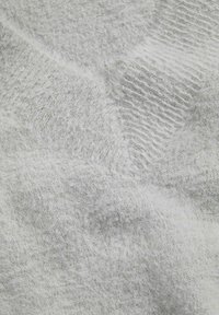 Blødt, lys gråt strikketrøje stof med en blanding af glatte og fluffy teksturer, synligt diagonalt ribbestrik mønster.