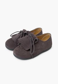 Zapatos de ante gris con punta redonda, detalle de flecos y cordones a juego. Incluyen un suave forro interior y una suela de goma negra.