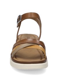 Brown leather sandal with multiple straps, silver buckle accent, cushioned footbed, and white rubber sole. Designed for comfort and support.