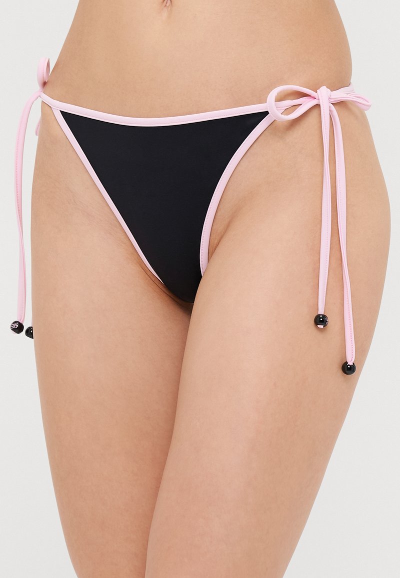 Schwarzer Bikini-Unterteil mit pinken Akzenten, ausgestattet mit verstellbaren Knoten an den Seiten und dekorativen schwarzen Perlen an den Knotenenden.