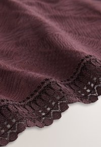 Tissu tricoté couleur marron foncé avec un motif texturé, bordure en dentelle festonnée à motif ajouré. Apparence douce et légèrement drapée.