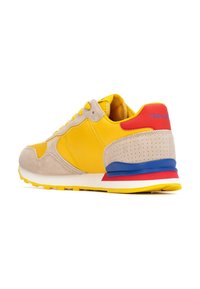 Baskets jaunes avec une tige en daim et cuir, accents beiges, talon bleu et rouge, panneau texturé, et semelle blanche avec un motif jaune.